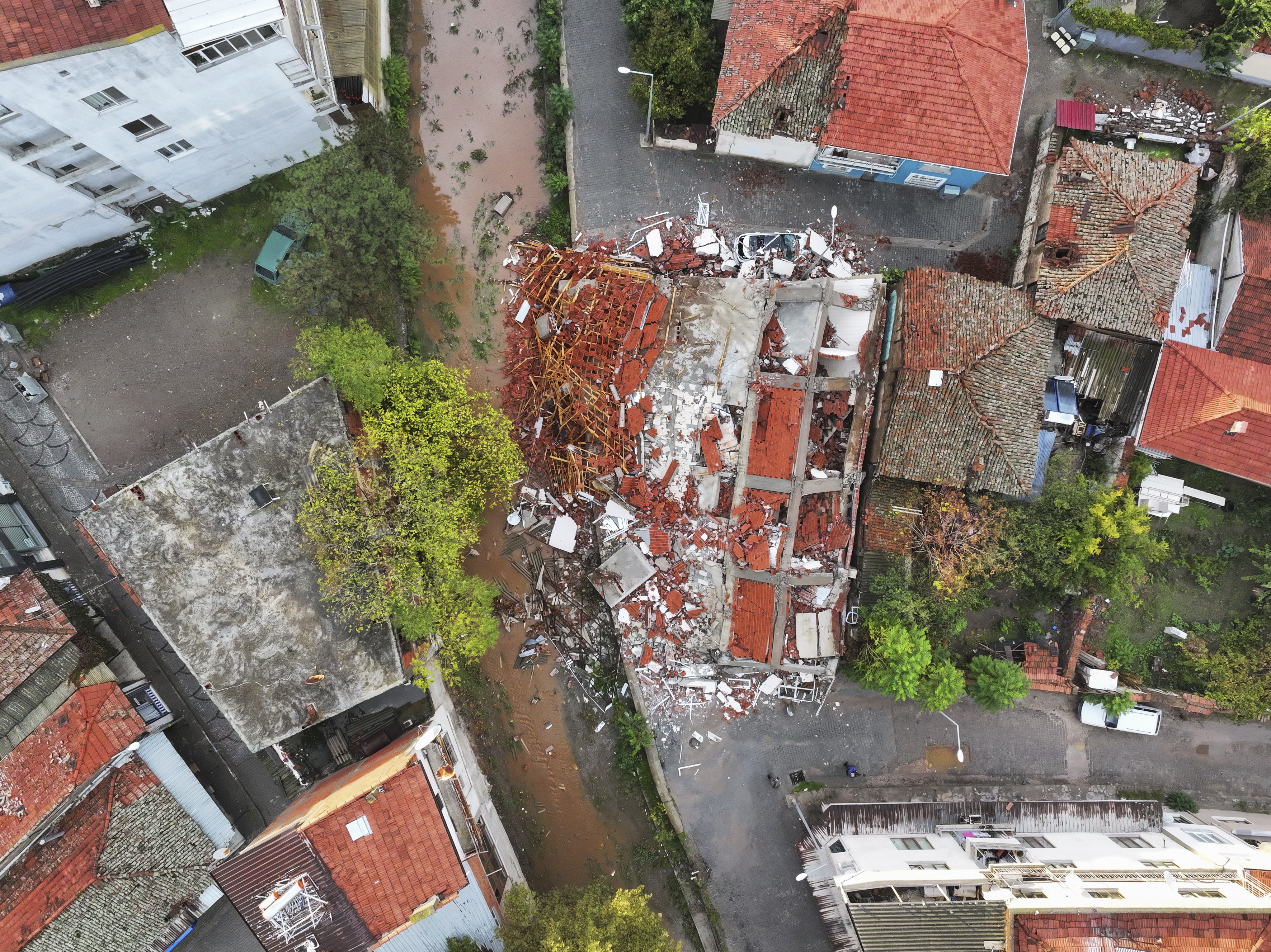 HASAR HAVADAN GÖRÜNTÜLENDİ
Depremin ardından sabahın ilk ışıklarıyla hasar tespit çalışmaları yoğunlaştırıldı. AA ekipleri, ilçede meydana gelen yıkım ve zararları dron ile havadan görüntüledi. Cumhuriyet Meydanı çevresinde bulunan iki bina tamamen çökerken, bir araç enkazın altında kaldı.